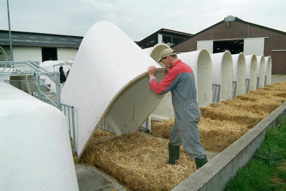 Gallery image of CalfOTel calf hutches; this is a worker lifting an Individual one to show how easy it is