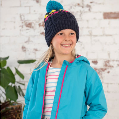 A girl wearing a bright teal jacket and a bobble hat