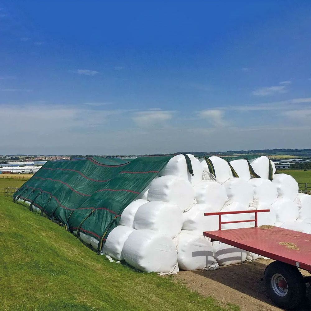 A stack of hay bales, covered by some Galebreaker fabric coverings