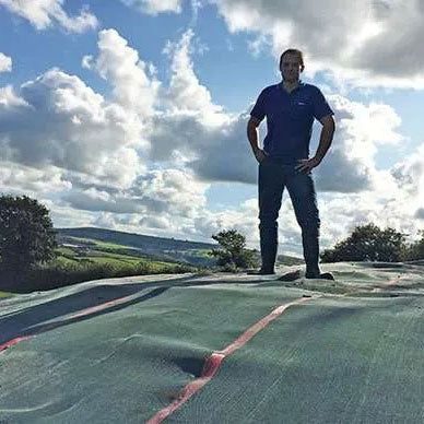 A proud gentleman standing atop his Galebreaker Silacover-covered silage